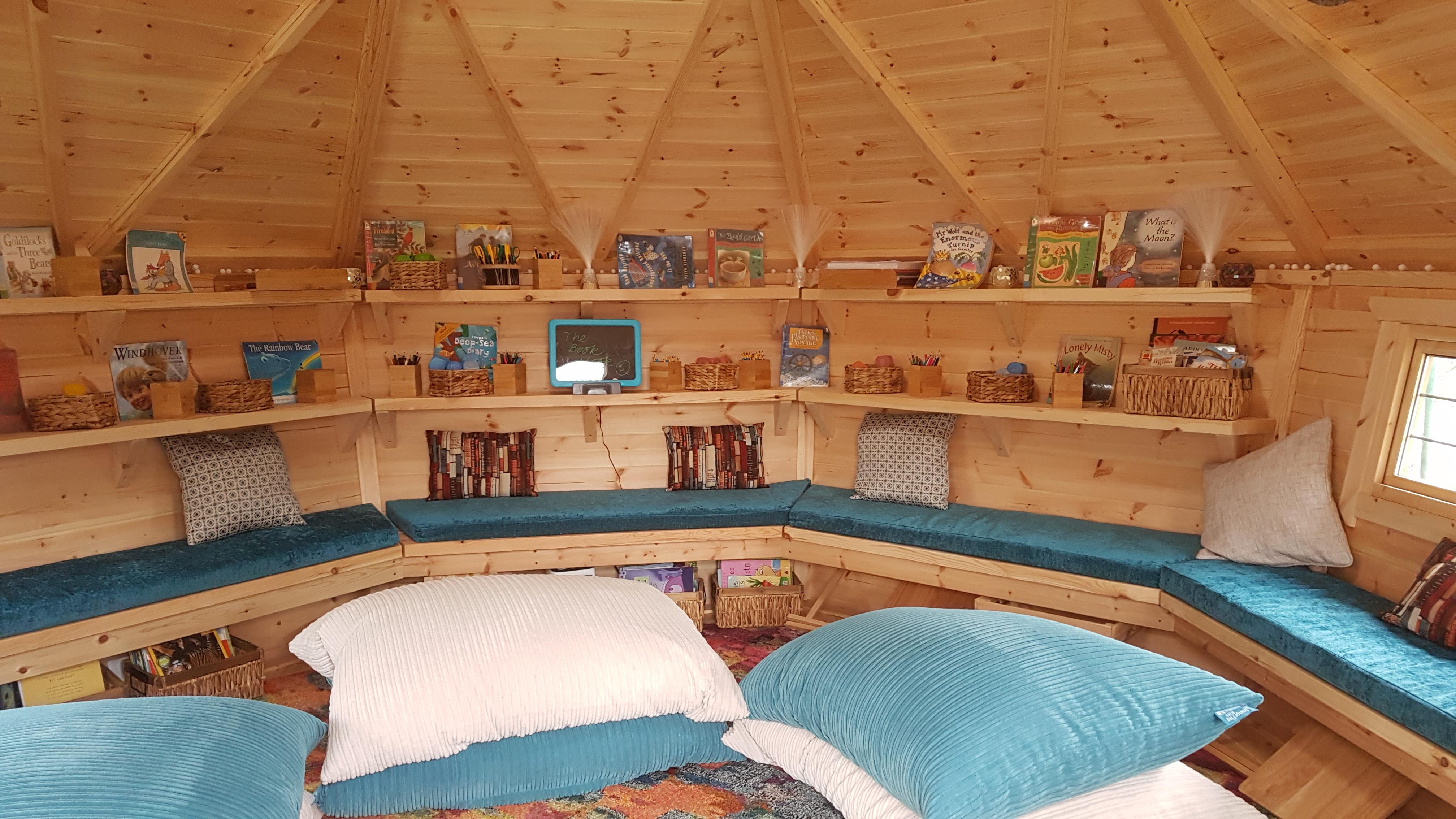 Interior of a timber school cabin set up as a reading nook