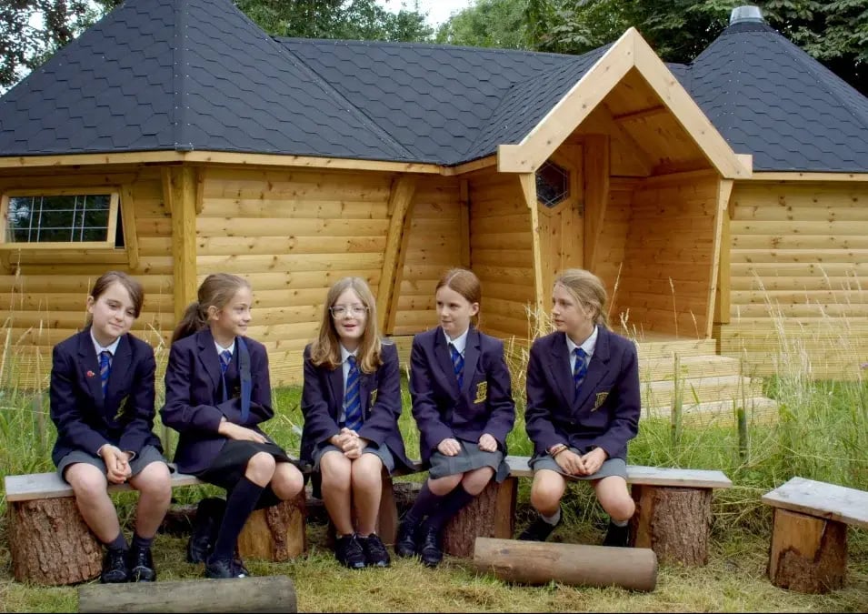 cutnall green pupils outside their forest school connected cabins