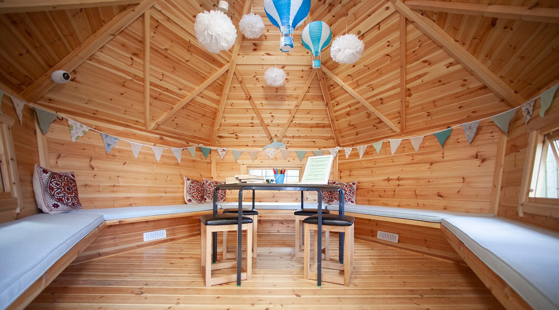 Interior of a timber forest school cabin with decor and desk