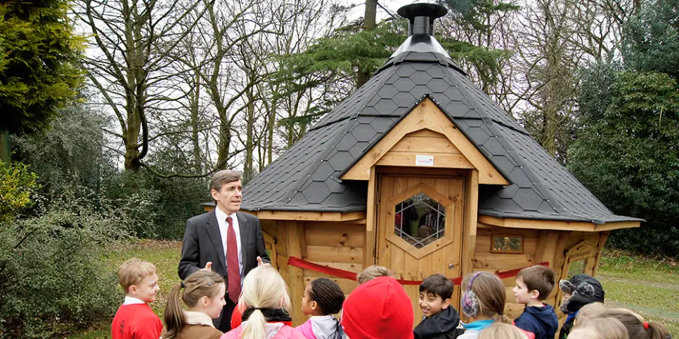 school children outside cabin with teacher ready for outdoor learning 